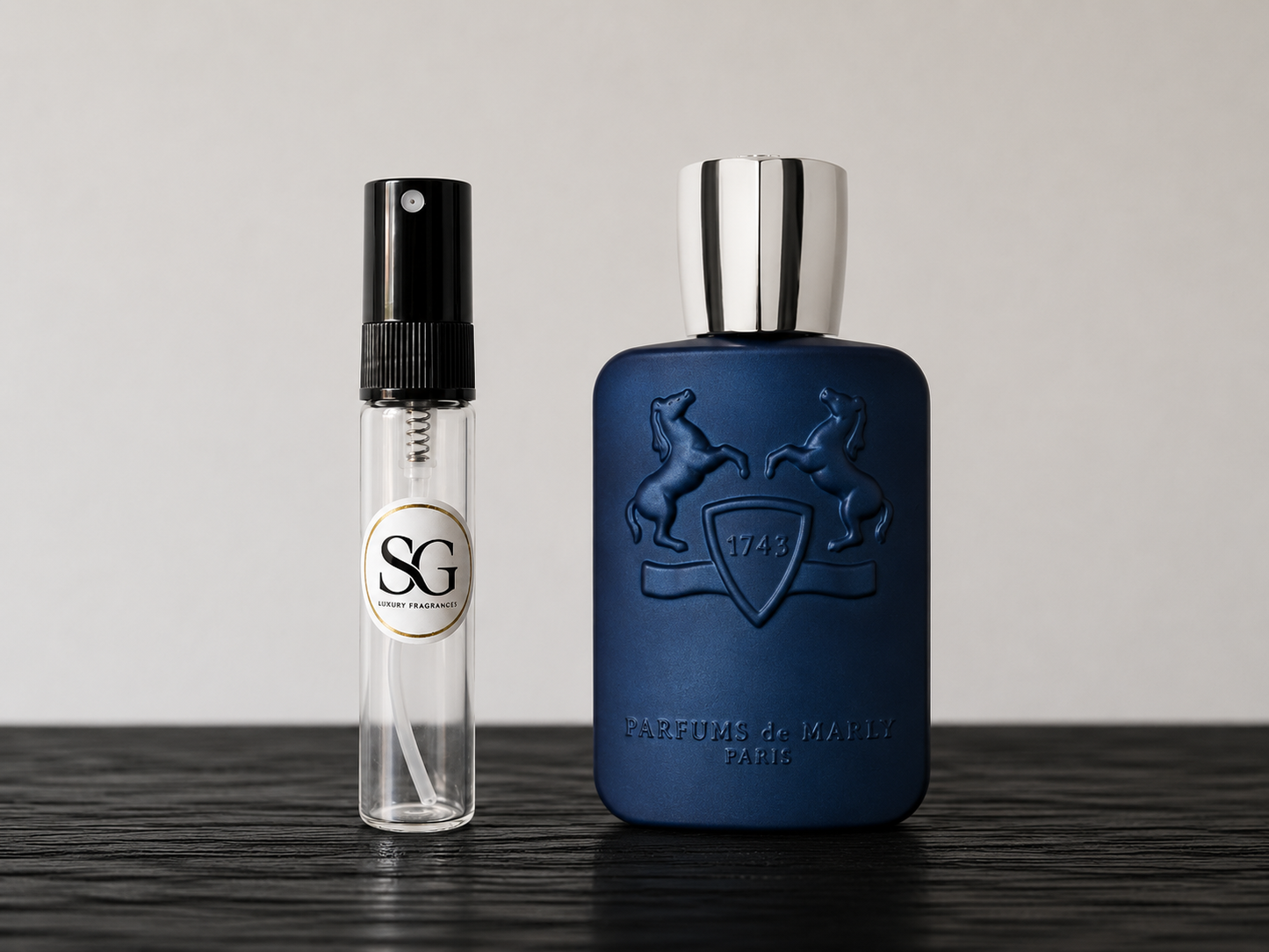 Two perfume bottles, one blue and one clear with black cap, on a wooden surface.