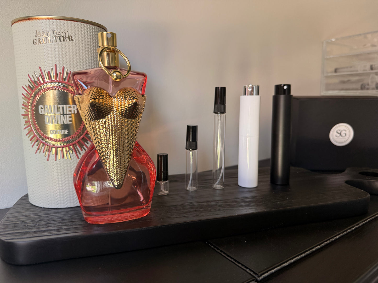 Perfume bottle with gold and red design on a shelf with other items.