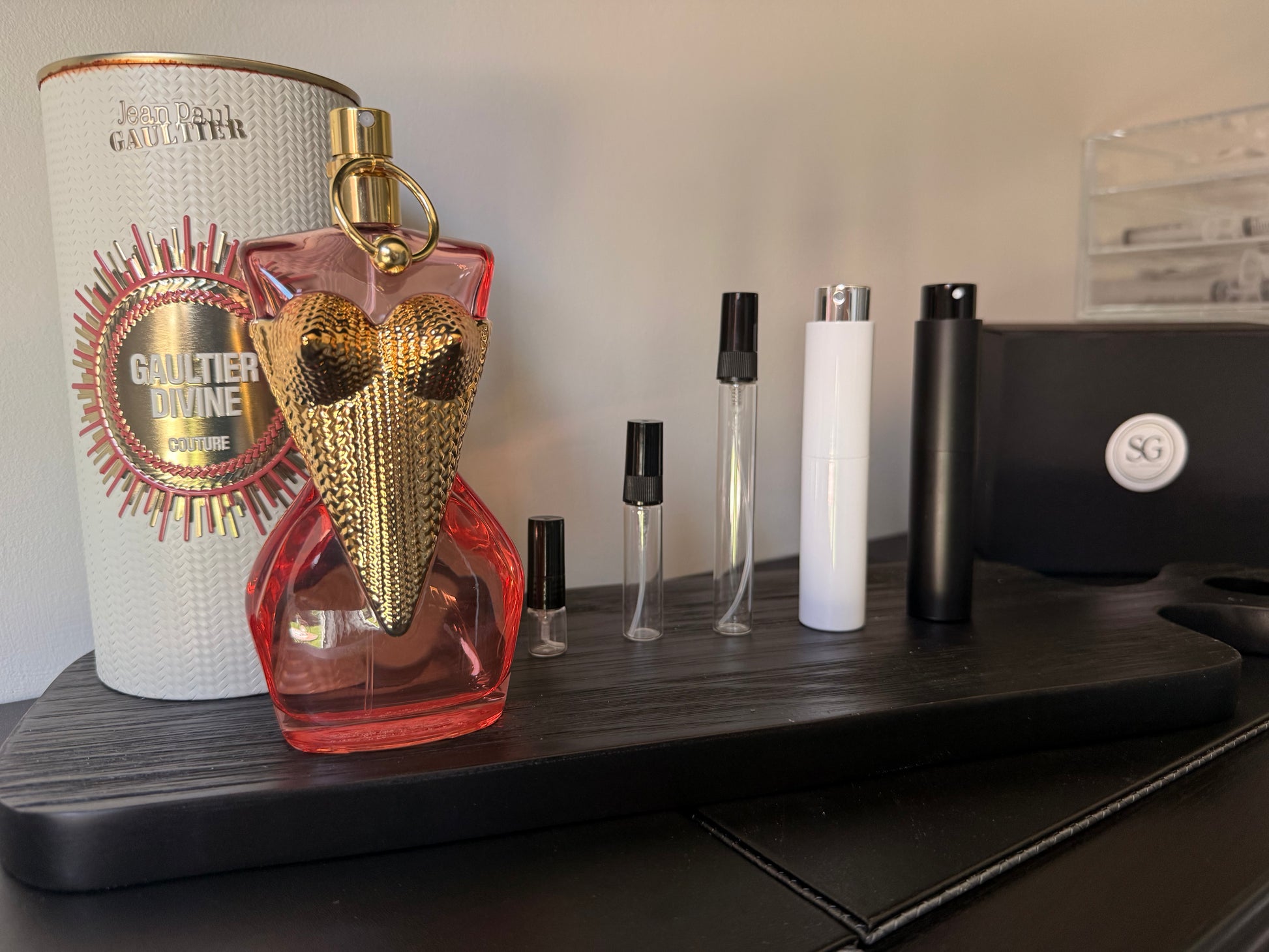 Perfume bottle with gold and red design on a shelf with other items.