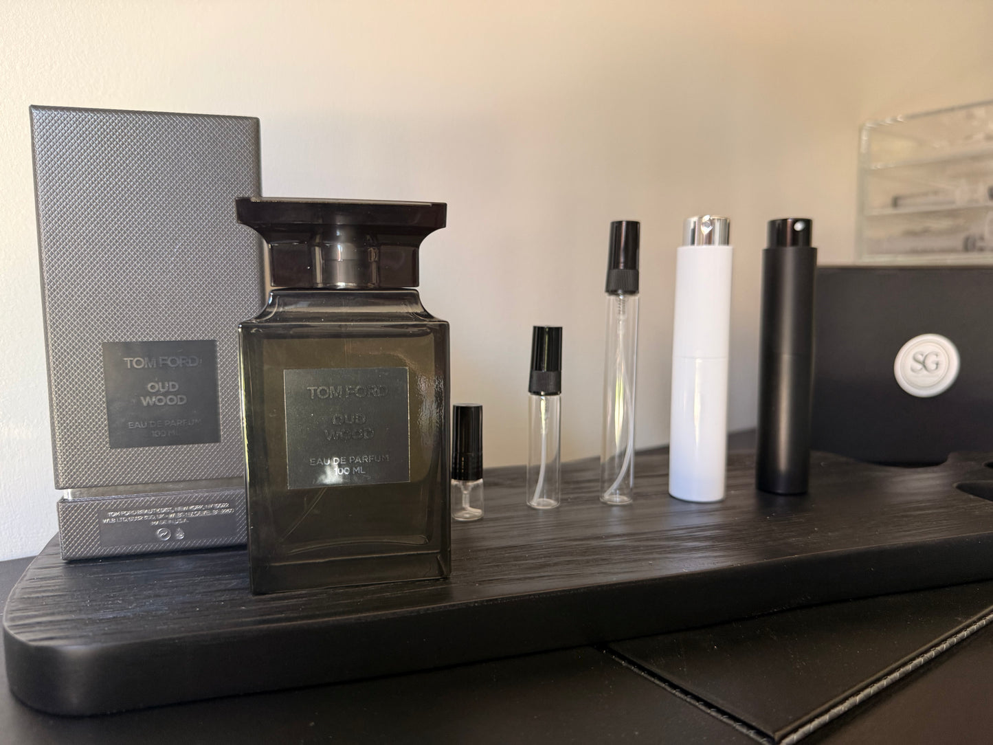 Collection of perfume bottles on a wooden surface with a neutral background
