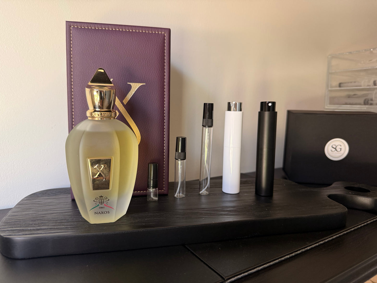 Perfume bottle and travel-sized bottles on a wooden surface with a blurred background