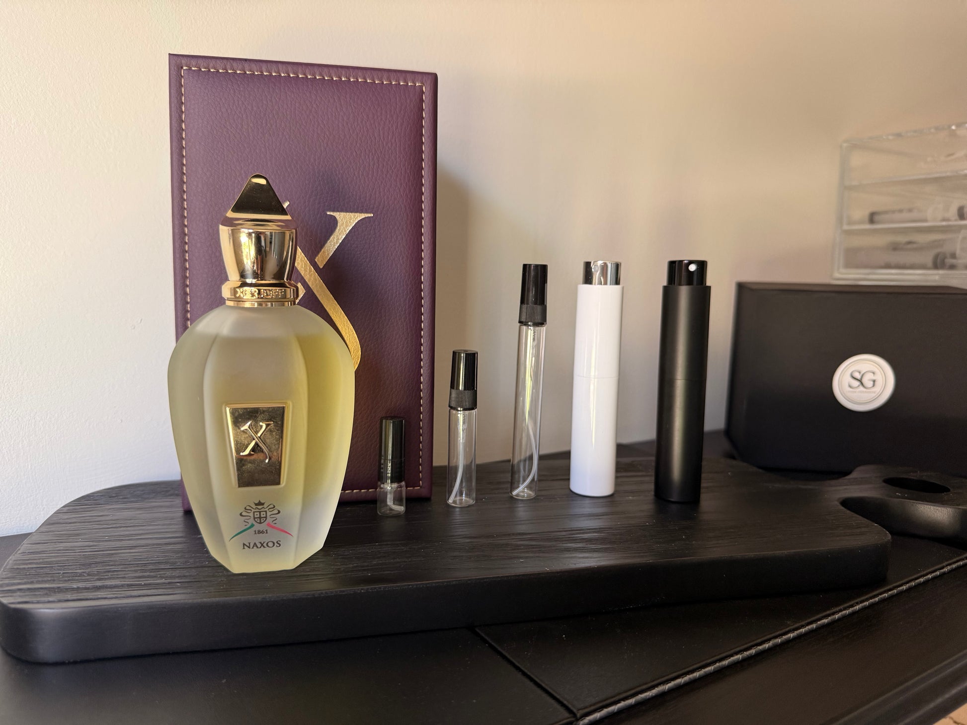 Perfume bottle and travel-sized bottles on a wooden surface with a blurred background