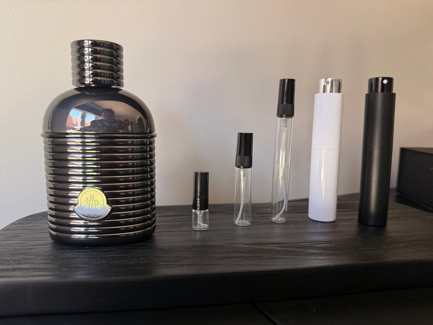 Set of various perfume bottles on a wooden surface with a neutral background