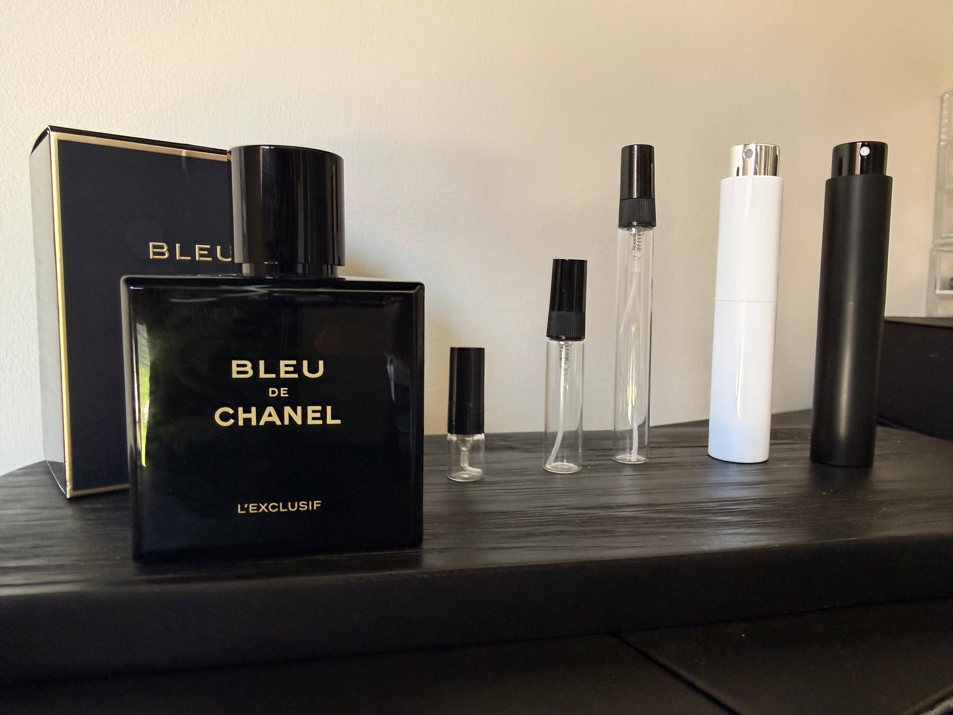 Bleu de Chanel perfume bottle and packaging on a wooden surface.