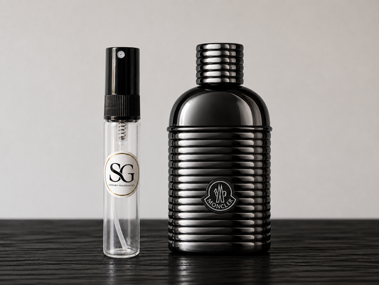Black perfume bottle and smaller spray bottle on a wooden surface with a neutral background