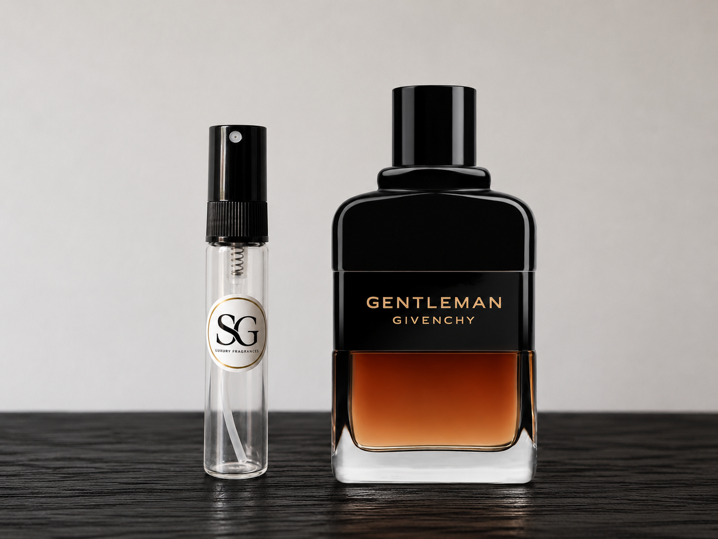 Two perfume bottles, one small and clear with a black cap, and the other large and black with 'Gentleman Givenchy' text, on a dark surface.
