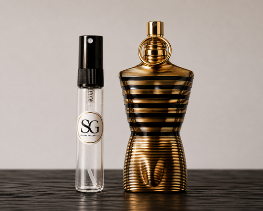 Gold and black striped perfume bottle next to a clear spray bottle with a logo on a wooden surface.