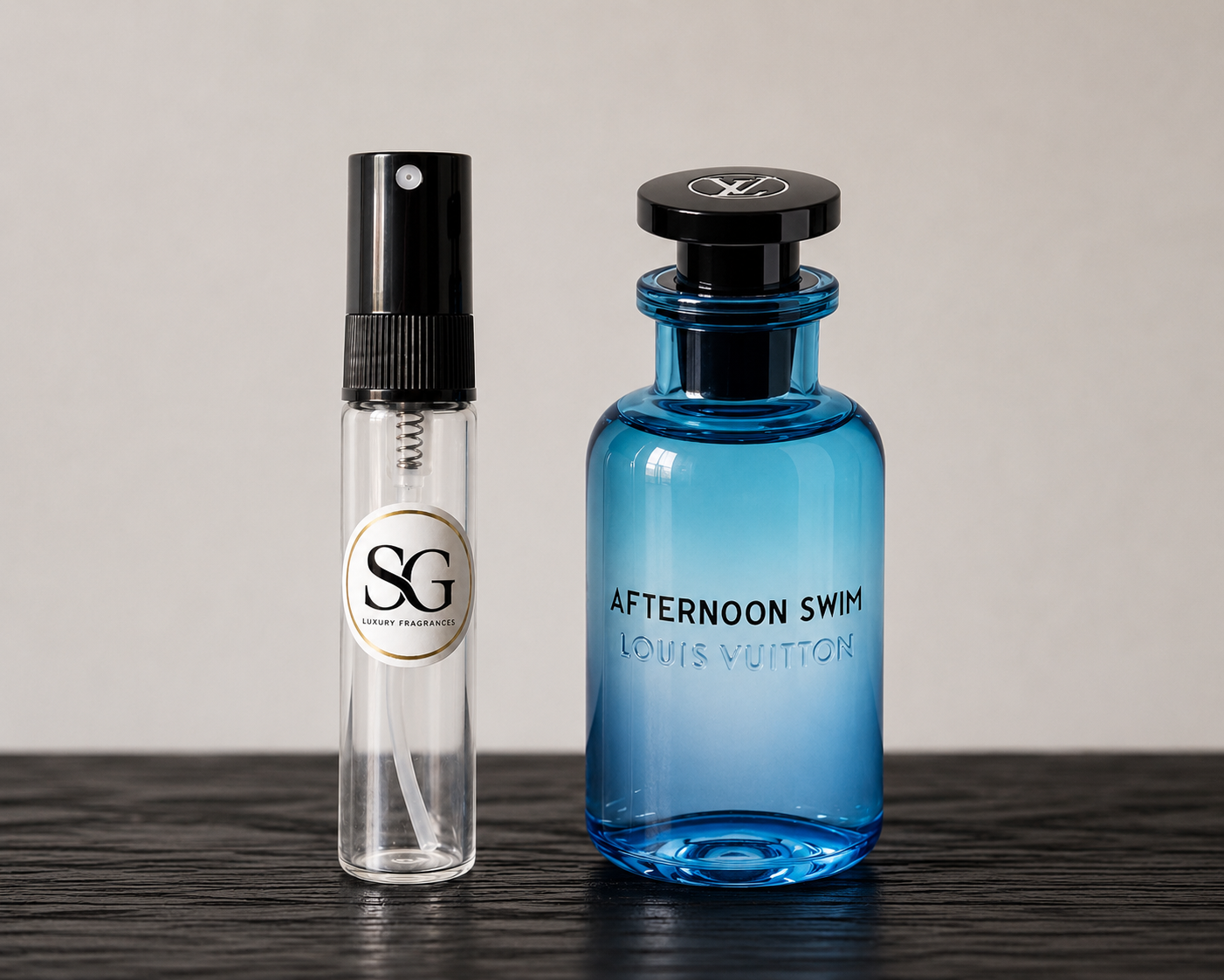 Two perfume bottles, one clear and one blue, on a dark surface with a neutral background.