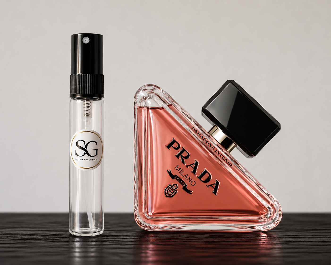 Two perfume bottles, one clear with a black cap and one pink with a black cap, on a wooden surface.