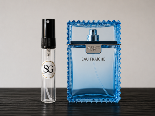 Blue Versace perfume bottle and small clear bottle with black cap on a dark surface.