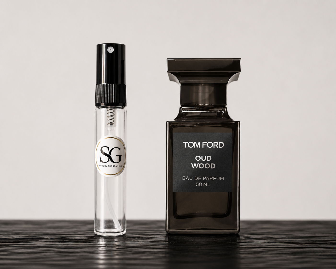 Two perfume bottles, one small and one large, on a reflective surface with a neutral background.