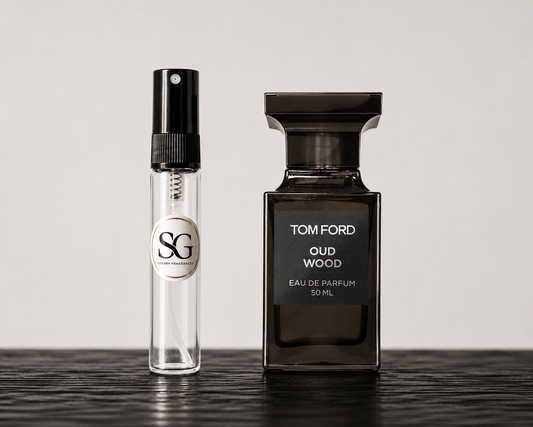 Two perfume bottles, one small and one large, on a reflective surface with a neutral background.