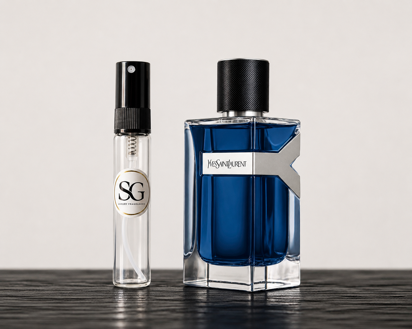 Two perfume bottles, one blue and one clear with black cap, on a dark surface.