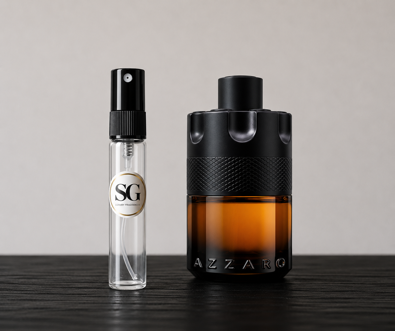Two perfume bottles, one small and clear with a black spray top, the other large and brown with a black cap, on a dark surface.