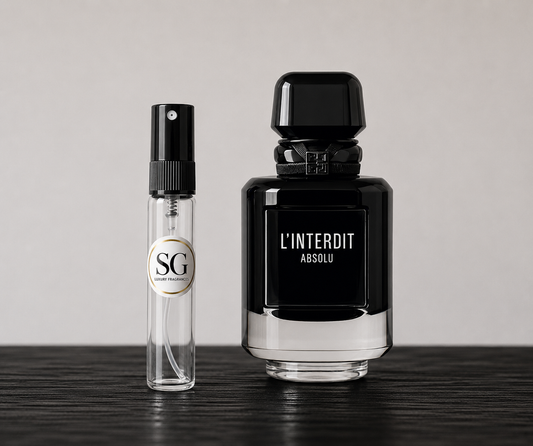 Two black perfume bottles labeled 'SG' and 'L'Interdit Absolu' on a wooden surface with a neutral background.