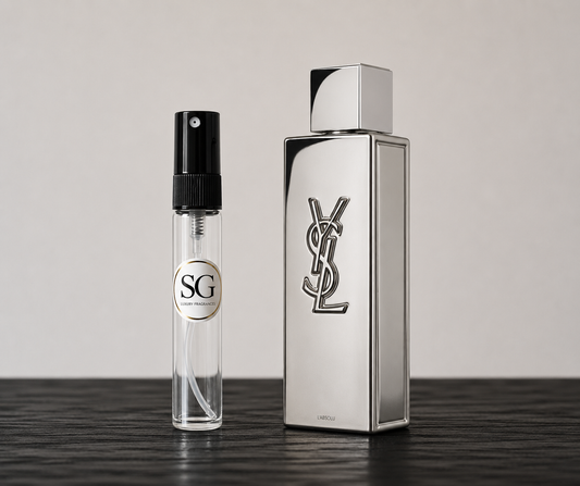 Two perfume bottles, one large and one small, on a dark surface with a light gray background.