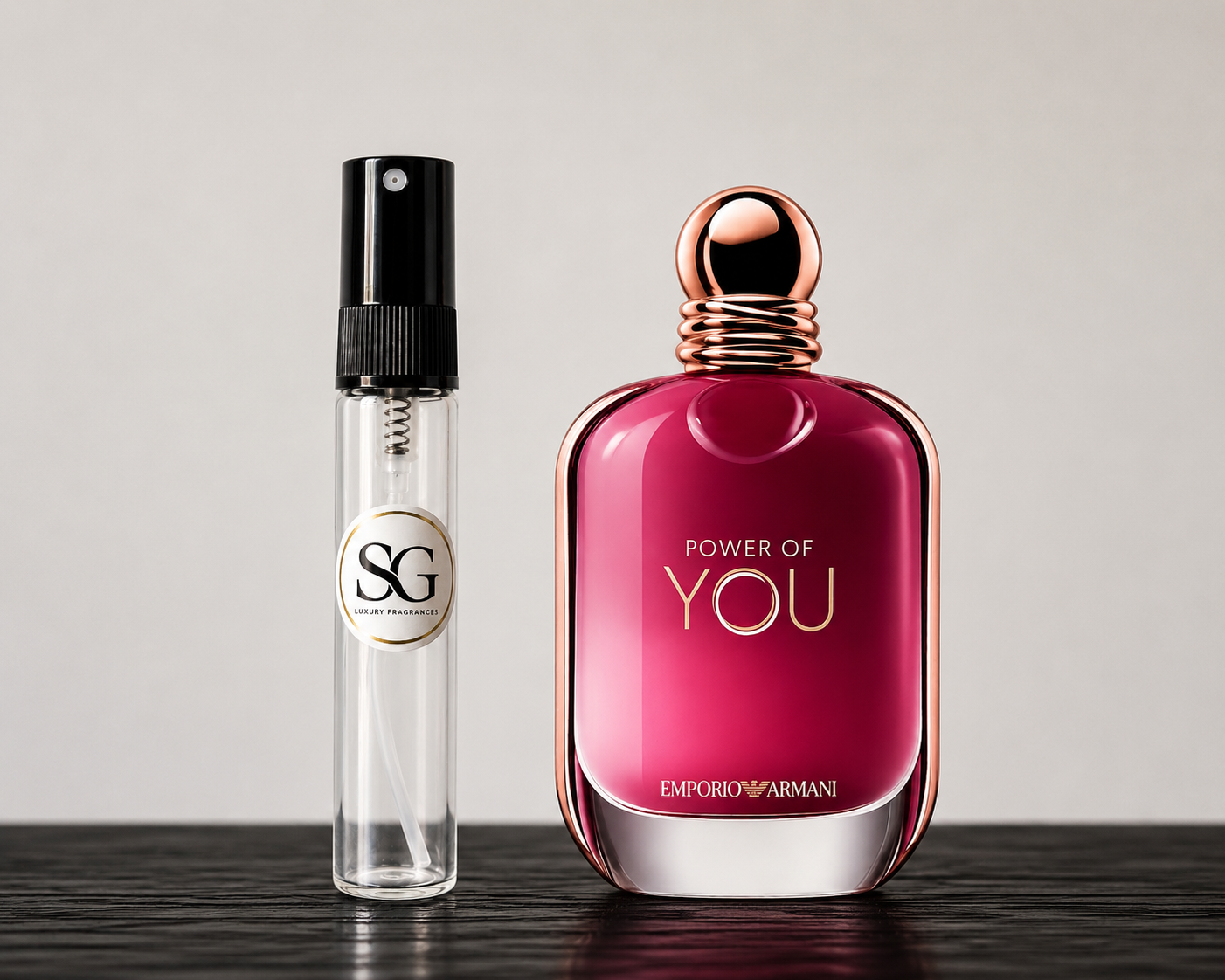 Two perfume bottles, one pink and one clear with black cap, on a wooden surface.