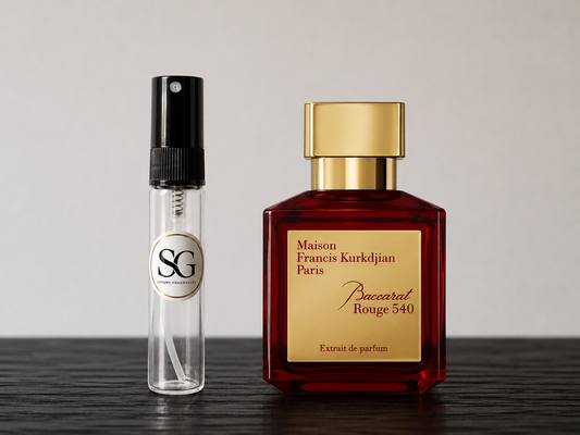 Two perfume bottles, one red and gold, the other clear with black cap, on a wooden surface.